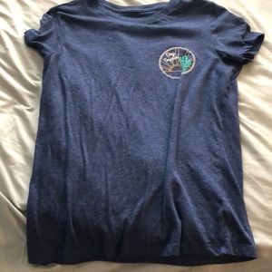 Blue tee shirt with small “day trippin” logo